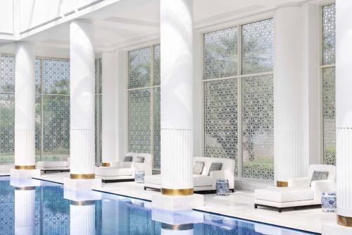 a lobby with a pool and chairs and windows at The Ritz-Carlton Rabat, Dar Es Salam in Rabat
