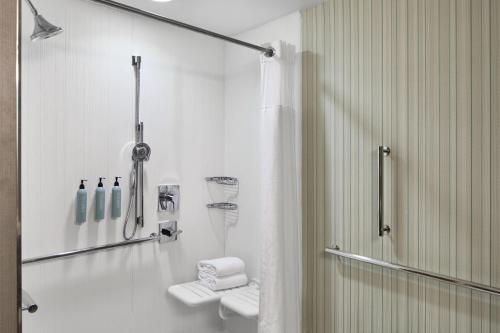 a white bathroom with a shower and a toilet at Courtyard by Marriott Atlanta NE/Duluth Sugarloaf in Duluth