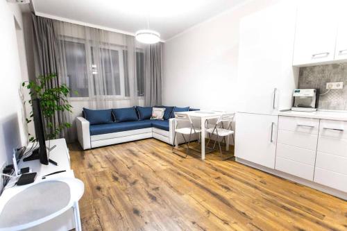 ein Wohnzimmer mit einem blauen Sofa und einem Tisch in der Unterkunft HOT Main Square Newly Built Modern Apartment in Burgas City