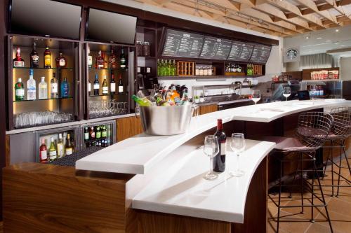 a bar with a counter with bottles of alcohol at Courtyard by Marriott Atlanta NE/Duluth Sugarloaf in Duluth