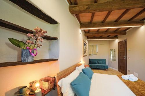 a bedroom with a blue couch and a vase of flowers at La Fuga Luxury Experience in Santa Fiora