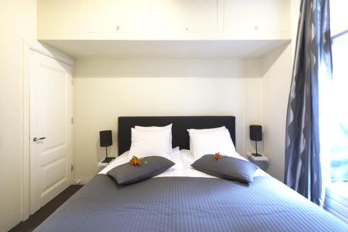 una camera da letto con un grande letto con due cuscini di Suite aan de A a Groninga (Groningen)