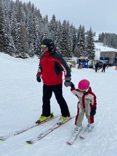 a man and a child on skis in the snow at Chalet Theresa in Bad Sankt Leonhard im Lavanttal