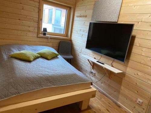 una camera da letto con un letto e una TV a schermo piatto di Chalet Theresa a Bad Sankt Leonhard im Lavanttal