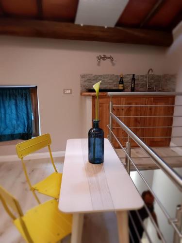 a vase sitting on a table with a yellow chair at La Fuga Luxury Experience in Santa Fiora