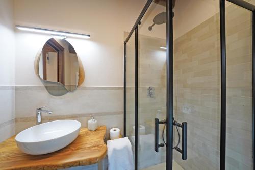 a bathroom with a sink and a glass shower at La Fuga Luxury Experience in Santa Fiora