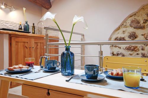 a table with a vase with flowers on it at La Fuga Luxury Experience in Santa Fiora