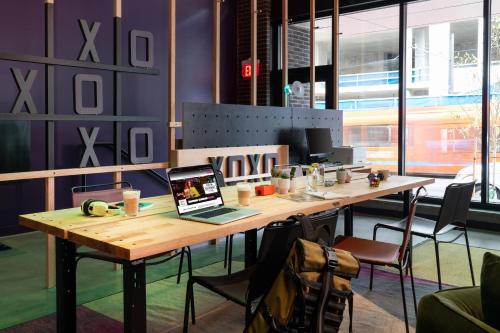 a table with a laptop computer on it in a room at Moxy Portland Downtown in Portland