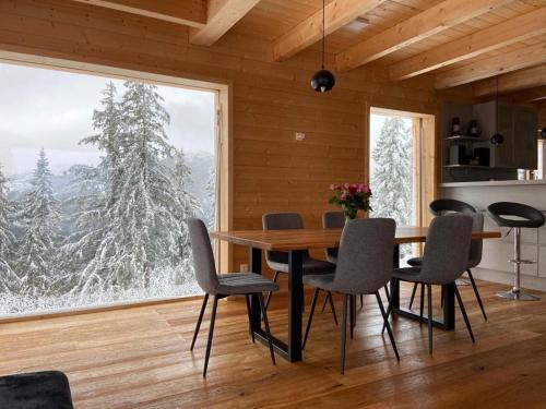 a dining room with a table and chairs and a large window at Chalet Theresa in Bad Sankt Leonhard im Lavanttal