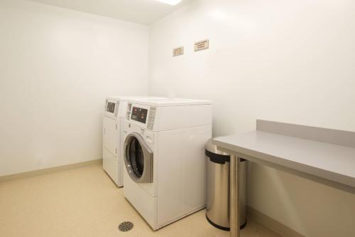 a laundry room with a washing machine and a counter at SpringHill Suites by Marriott Seattle Issaquah in Issaquah