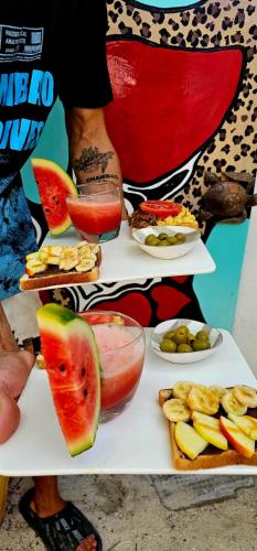 a person standing next to a plate of food with fruit at Chambao Maldives in Guraidhoo
