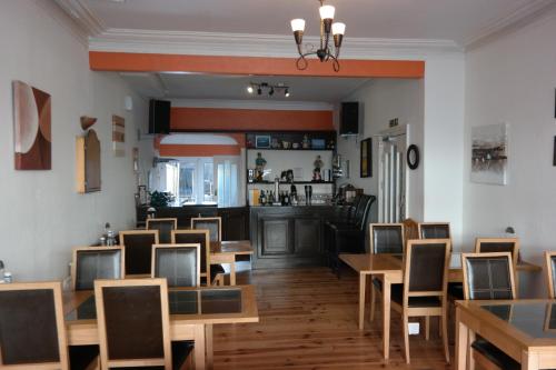ein Restaurant mit Holztischen und -stühlen und einer Bar in der Unterkunft Shananagens Guesthouse in Blackpool