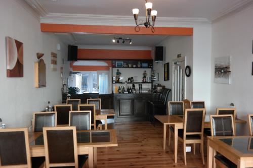 a restaurant with wooden tables and chairs and a bar at Shananagens Guesthouse in Blackpool