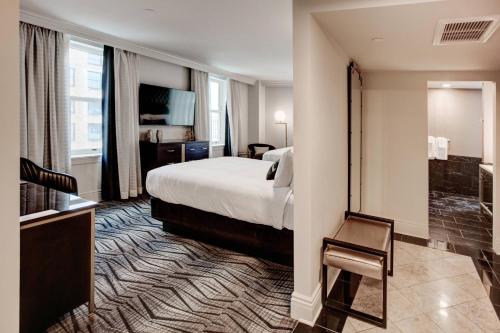 a hotel room with a bed and a chair at The Warrior Hotel, Autograph Collection in Sioux City