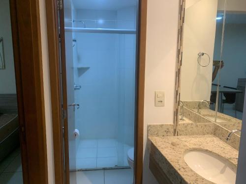 カルダス・ノバスにあるPRIVÉ RIVIERA PARK Apto Hotelの洗面台と鏡付きシャワーを備えたバスルーム