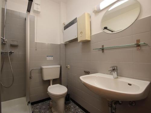 a bathroom with a sink and a toilet and a mirror at Bungalow in Dornumersiel in Dornumersiel