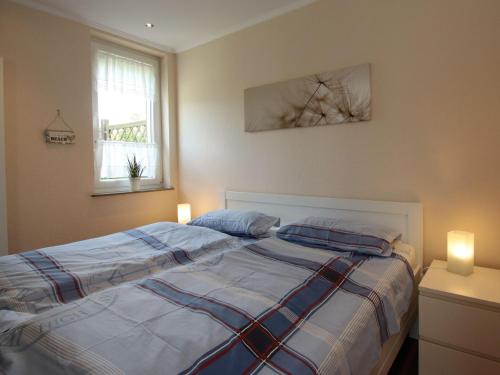 a bedroom with a bed with two pillows at Bungalow in Dornumersiel in Dornumersiel
