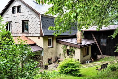 a large house with a black roof and a black at Chalupa pod stromy in Kovářská