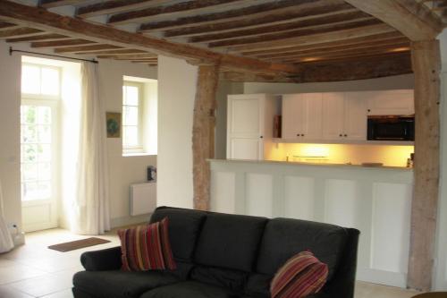 un salon avec un canapé et une cuisine dans l'établissement Gite La Londe, à Longueville