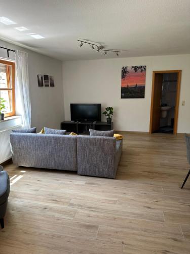 a living room with a couch and a television at Ferienwohnung Hermosa in Stegaurach