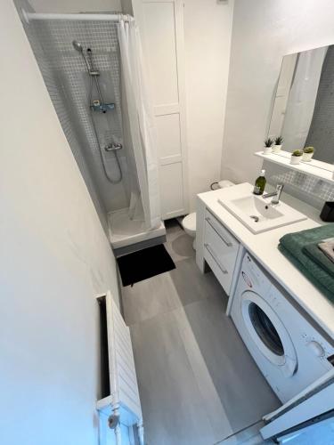 La salle de bains blanche est pourvue d'un lavabo et d'un lave-linge. dans l'établissement Studio marseille calanques, à Marseille