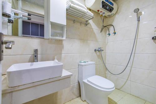 Un baño con lavabo, inodoro y ducha. en SkyInn-Europark, en Shenzhen