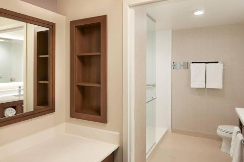 a bathroom with a toilet and a sink and a mirror at Residence Inn by Marriott Toronto Mississauga Southwest in Mississauga