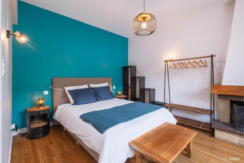 a bedroom with a large bed with a blue wall at Maison SAUTREAU Bout du Lac in Doussard