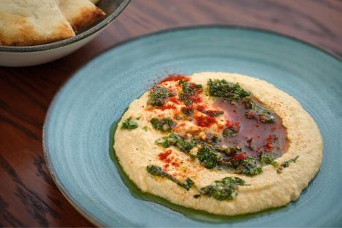 a blue plate with an omelet on a table at The Reach at Piccadilly, Manchester, a Tribute Portfolio Hotel in Manchester