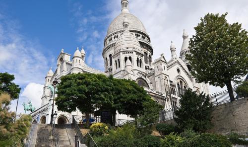un grand bâtiment blanc avec un escalier devant dans l'établissement Hôtel du Terrage, à Paris