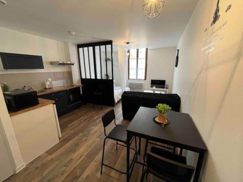 un salon avec une table et une cuisine dans l'établissement Grand studio 1er étage au calme centre ville proximité Cathédrale, à Orléans