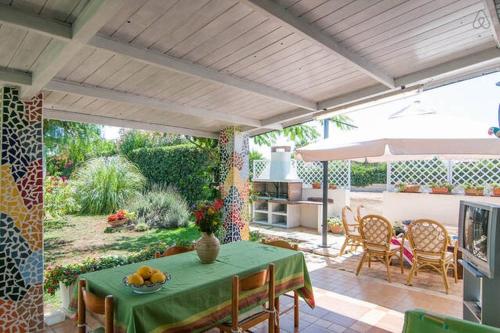 un patio con mesa y mantel verde en Villa Penelope, en Granelli