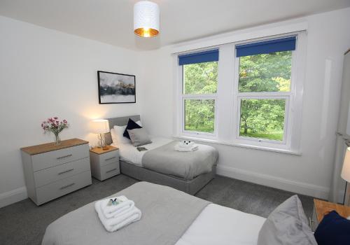 a bedroom with two beds and a window at Park View House Close to Central Park and Plymouth Argyle FC - Dogs welcome - Hosted by Absolute Accommodation Plymouth in Plymouth
