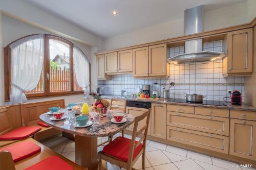 une cuisine avec une table, des chaises, une table et une fenêtre dans l'établissement Maison SAUTREAU Bout du Lac, à Doussard