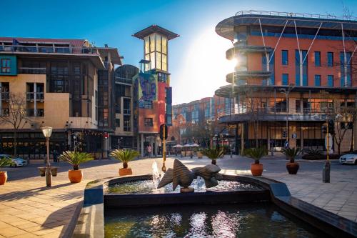 a fountain in the middle of a city with buildings at Johannesburg Marriott Hotel Melrose Arch in Johannesburg