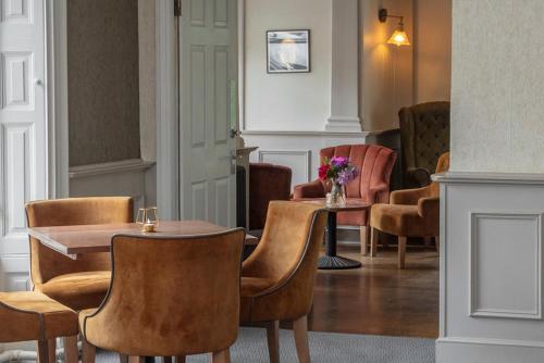 a dining room with chairs and a table with flowers on it at Best Western Valley Hotel in Ironbridge