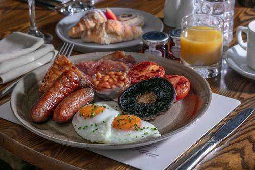 a plate of breakfast food on a wooden table at Best Western Valley Hotel in Ironbridge
