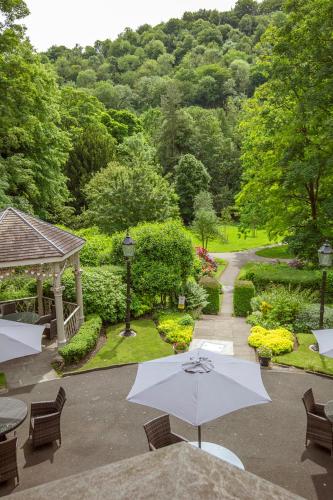a garden with a gazebo and chairs and an umbrella at Best Western Valley Hotel in Ironbridge