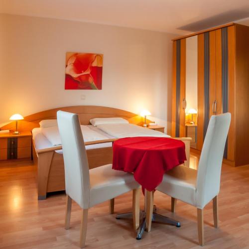 a bedroom with a bed and a table and chairs at Waldpension Schiefling am See in Schiefling am See