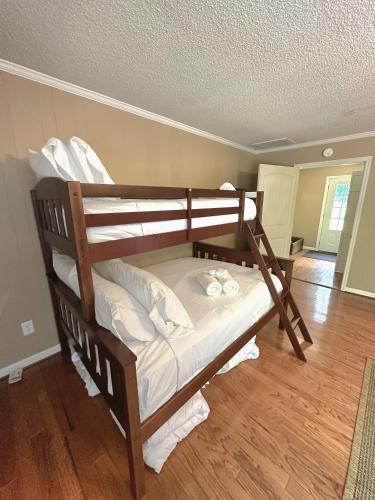 a wooden bunk bed in a room with wood floors at Lady of the Lake in Chapin