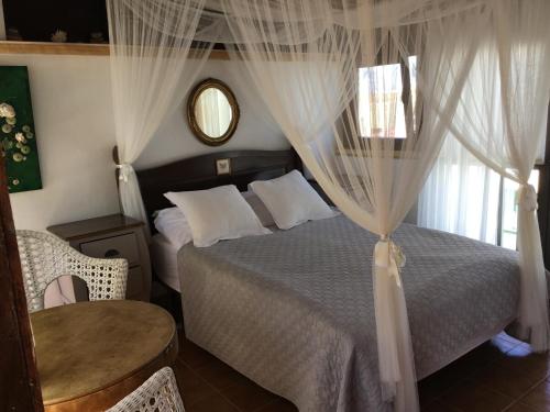 a bedroom with a bed with curtains and a table at Casa Vivien in Cotillo
