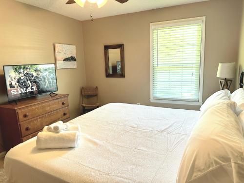 a bedroom with a white bed and a television at Lady of the Lake in Chapin