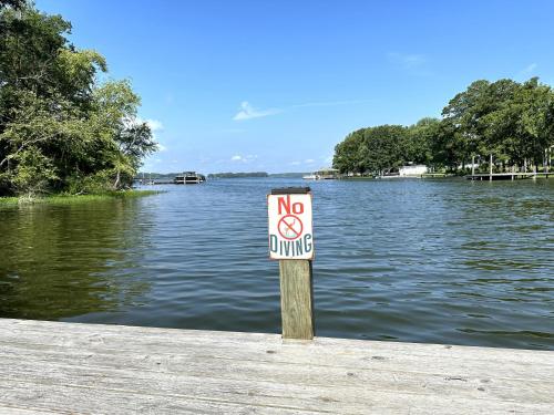 a no swimming sign on a dock in a lake at Lady of the Lake in Chapin