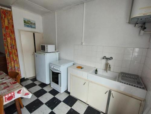 une petite cuisine avec un réfrigérateur et un évier dans l'établissement La plaisance, à Notre-Dame-de-Monts