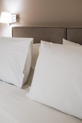two white pillows sitting on top of a bed at Luxury Beachfront Apartment in Kalamata Modern, Spacious & Sea View Balcony in Kalamata