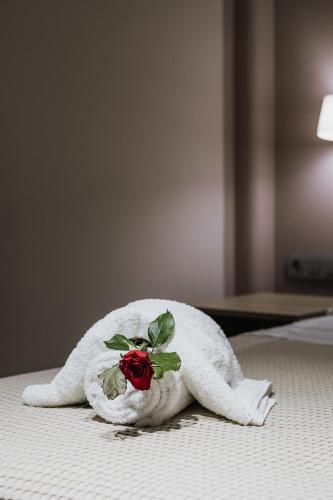 a towel animal with a rose on a bed at Luxury Beachfront Apartment in Kalamata Modern, Spacious & Sea View Balcony in Kalamata