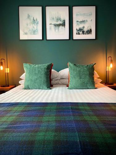 a bedroom with a bed with two green pillows at Lochside Guest House in Arrochar