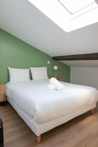 Cette chambre comprend un grand lit blanc et des murs verts. dans l'établissement Toscana Casa Maja - Terrasse - Parking privé, à Saint-Étienne