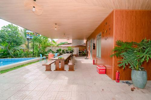 an outdoor patio with benches and a pool at Wooden Homestay LAGI in Hàm Tân