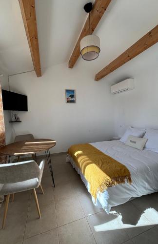 une chambre avec un lit, une table et un bureau dans l'établissement Appartement 2 personnes bord de mer, à Sagone